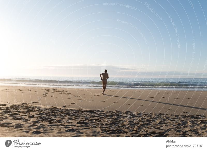 Nackter Mann rennt befreit am leeren Strand auf das wellige Meer zu nackt rennen Sehnsucht Geschwindigkeit Freiheit unabhängig Fußspuren Sand Ziel Sommer Wellen