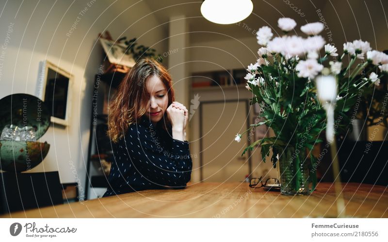 Young woman sitting dreamily at the living room table feminin 1 Mensch 18-30 Jahre Jugendliche Erwachsene 30-45 Jahre Häusliches Leben gemütlich