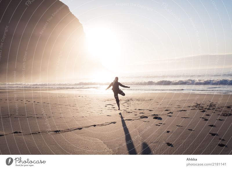 Junge Frau tanzt am Strand im Sonnenuntergang Spielen Ferien & Urlaub & Reisen Abenteuer Ferne Freiheit 1 Mensch Natur Berge u. Gebirge Wellen Meer Lofoten