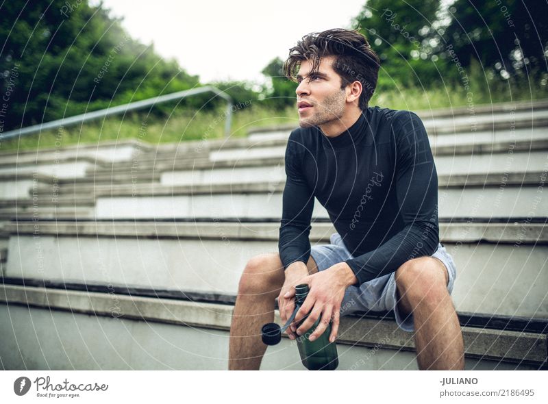 Junger Sportler sitzt im Treppenhaus mit Trinkflaschenbruch Trinkwasser Lifestyle Freude Körper Gesundheit Gesunde Ernährung Gesundheitswesen sportlich muskulös