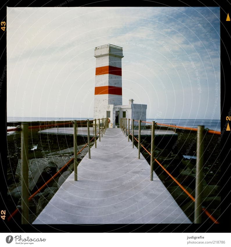 Island Natur Himmel Klima Schönes Wetter Küste Meer Leuchtturm Bauwerk Gebäude eckig rot Einsamkeit Ferien & Urlaub & Reisen Orientierung Navigation Steg