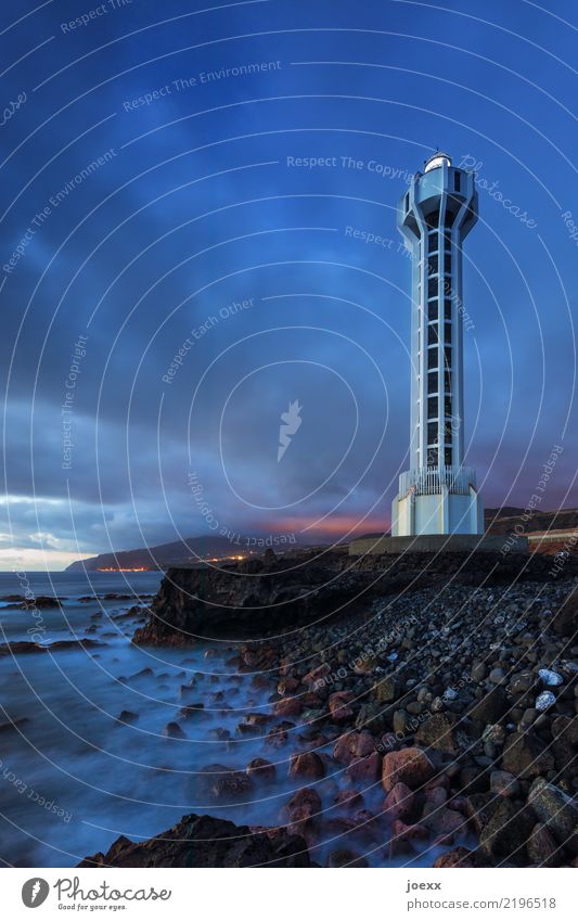 Faro de Punta Lava Wasser Himmel Wolken Schönes Wetter Felsen Wellen Küste Meer Leuchtturm hoch maritim modern blau braun weiß Sicherheit Farbfoto Außenaufnahme