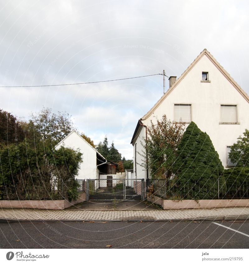 nachbarschaft Himmel Wolken Pflanze Baum Sträucher Haus Tor Bauwerk Gebäude Architektur Straße Wege & Pfade trist grau grün weiß Einfamilienhaus Farbfoto