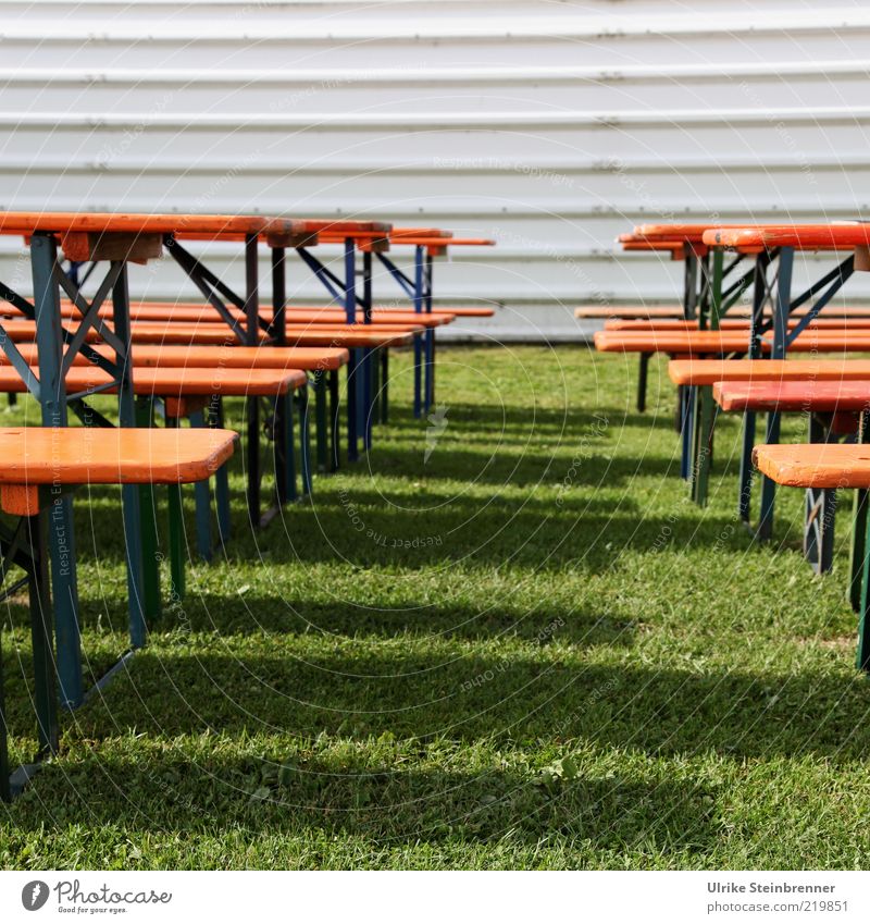 Bierzeltgarnituren im Sonnenlicht vor Flughalle Biertische Bank Gras Wiese Holz stehen leer Schatten Linie Metall Farbfoto Außenaufnahme Menschenleer Tag