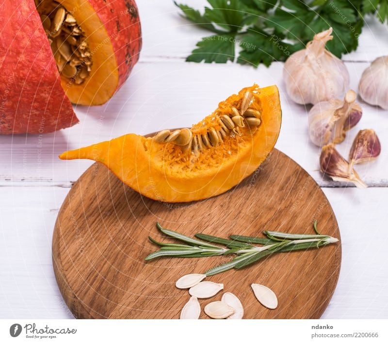 Stück frischer Kürbis mit Samen Gemüse Suppe Eintopf Essen Abendessen Vegetarische Ernährung Dekoration & Verzierung Tisch Halloween Natur Herbst Holz gelb