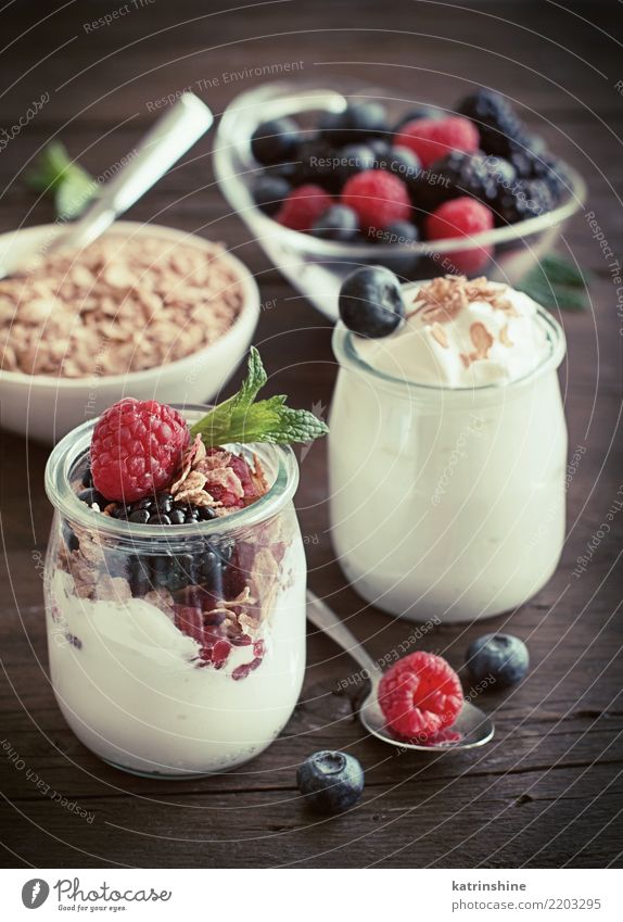 Beeren, Flocken und frischer griechischer Jogurt auf einem Holztisch Joghurt Dessert Ernährung Frühstück Diät Schalen & Schüsseln natürlich blau braun rot