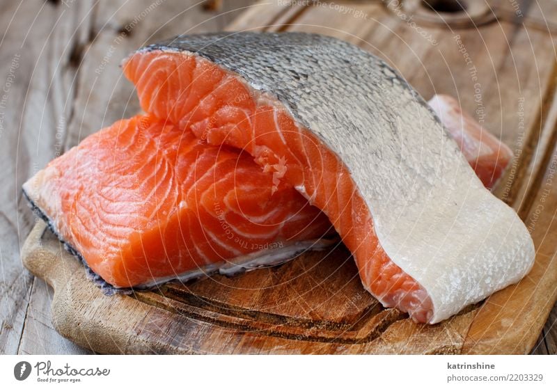 Frische rohe Lachse auf einem hölzernen Schneidebrett Fisch Meeresfrüchte Ernährung Essen Abendessen Diät Tisch frisch rot Hintergrund Holzplatte