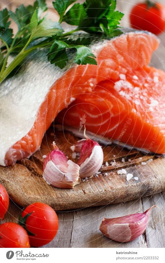 Frische rohe Lachse auf einem hölzernen Schneidebrett Fisch Meeresfrüchte Gemüse Kräuter & Gewürze Ernährung Essen Abendessen Diät Tisch frisch rot Hintergrund