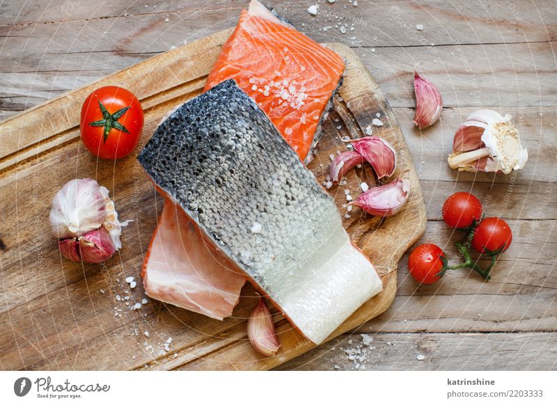 Frische rohe Lachse und Gemüse auf einem hölzernen Schneidebrett Fisch Meeresfrüchte Kräuter & Gewürze Ernährung Essen Abendessen Diät Tisch frisch oben rot