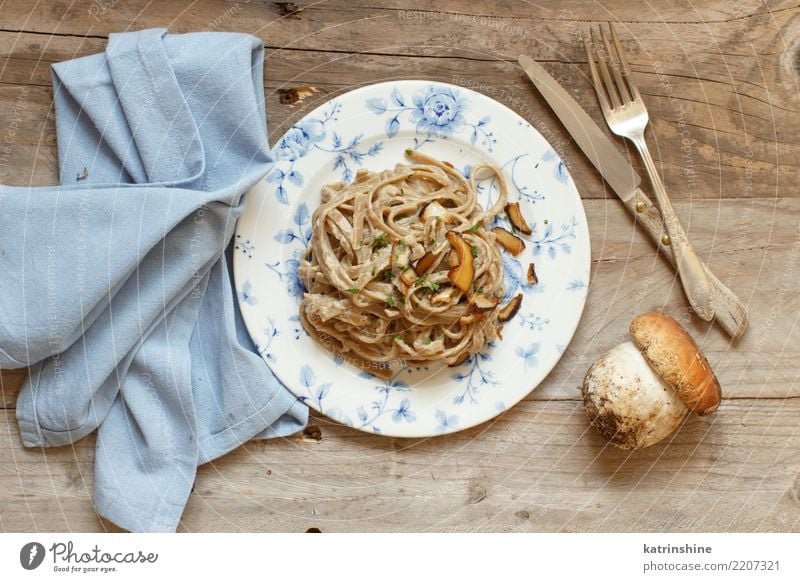 Vollkorn Tagliolini mit Pilzen Porcini Gemüse Mittagessen Abendessen Vegetarische Ernährung Teller frisch lecker oben gelb weiß Steinpilze Champignon Sahne