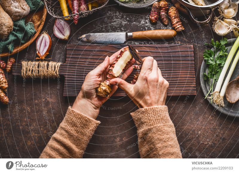 Weibliche Hände schälen Topinambur auf Küchentisch Lebensmittel Gemüse Suppe Eintopf Kräuter & Gewürze Öl Ernährung Mittagessen Abendessen Bioprodukte