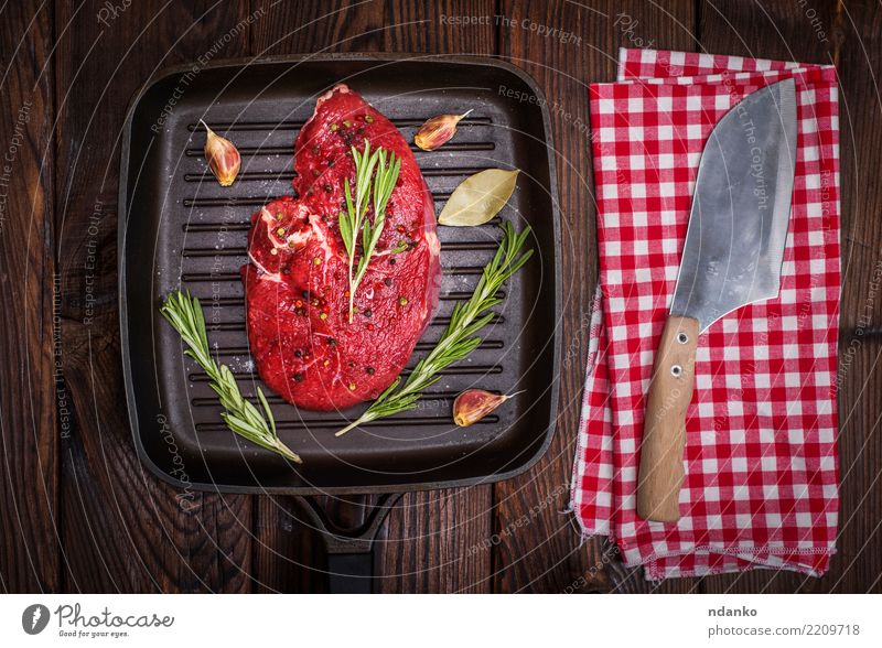 rohes Rindersteak in Gewürzen Lebensmittel Fleisch Kräuter & Gewürze Abendessen Pfanne Messer Tisch Holz Essen frisch braun grün rot Mahlzeit Rindfleisch