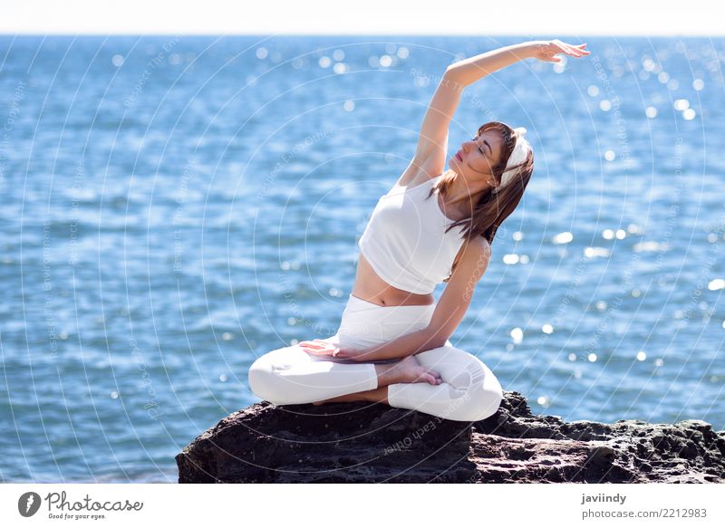 Junge Frau, die Yoga im Strand tut. Lifestyle schön Wellness Erholung Meditation Sommer Meer Sport Mensch Erwachsene Natur Fitness sitzen Fröhlichkeit natürlich