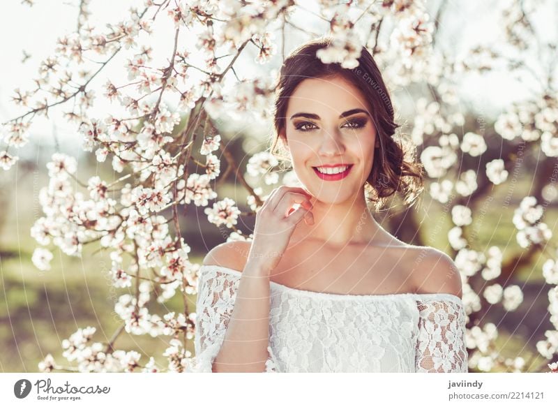 Frau, die im Frühjahr in der geblühten Zeit des Gartens lächelt Stil Glück schön Haare & Frisuren Gesicht Hochzeit Mensch Erwachsene Natur Baum Blume Blüte Park