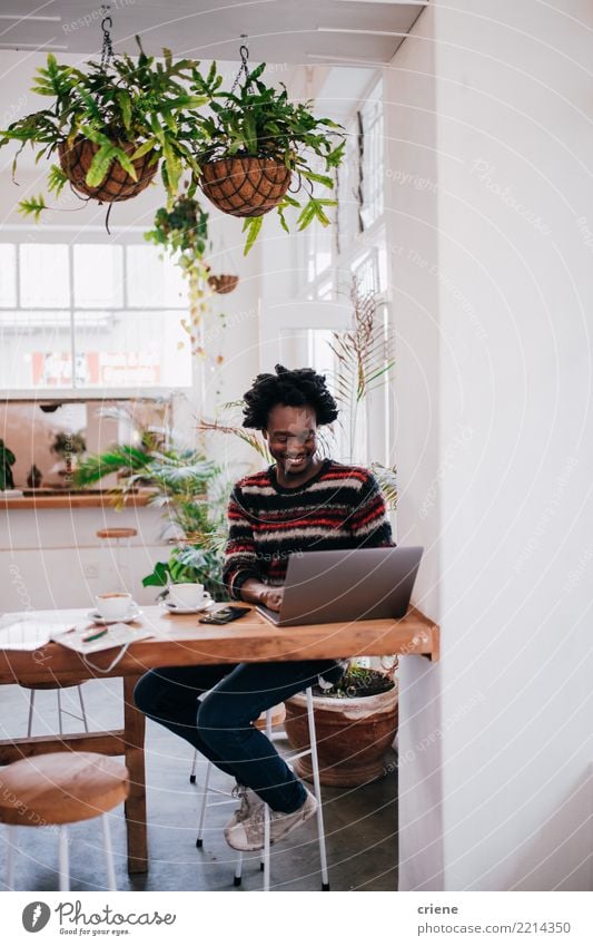 Junger afroamerikanischer Geschäftsmann, der mit dem Laptop im Café arbeitet. Frühstück Getränk trinken Kaffee Espresso Lifestyle Restaurant