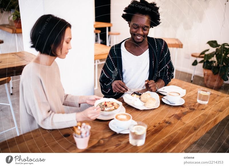 Mixed Race Paar beim gemeinsamen Frühstücken im Restaurant Lebensmittel Essen Kaffeetrinken Getränk Espresso Schalen & Schüsseln Lifestyle Freude Glück Erholung