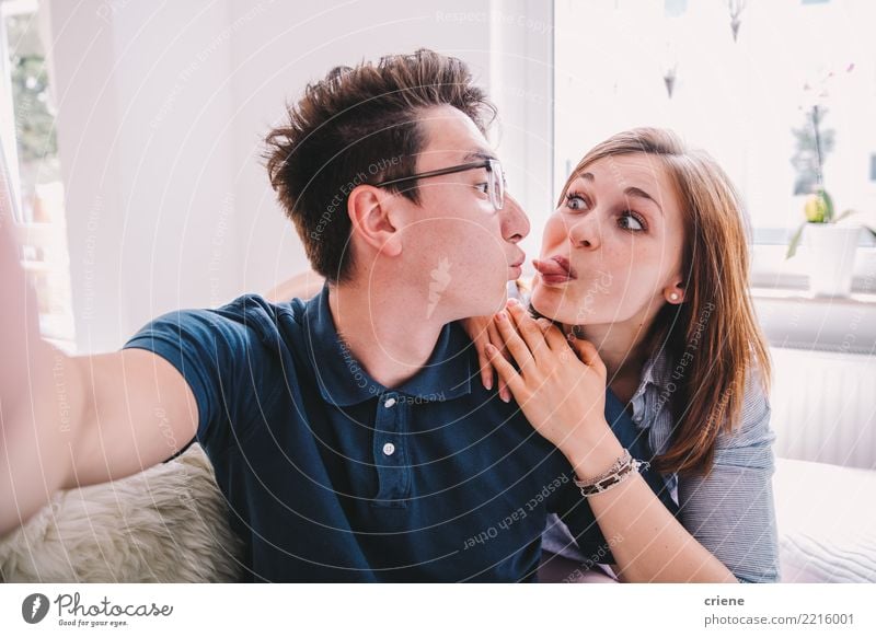 Mixed Race Paar nimmt lustigen Selfie mit Telefon zusammen. Freude Gesicht Freizeit & Hobby Haus Wohnzimmer Fotokamera Technik & Technologie Mensch Frau