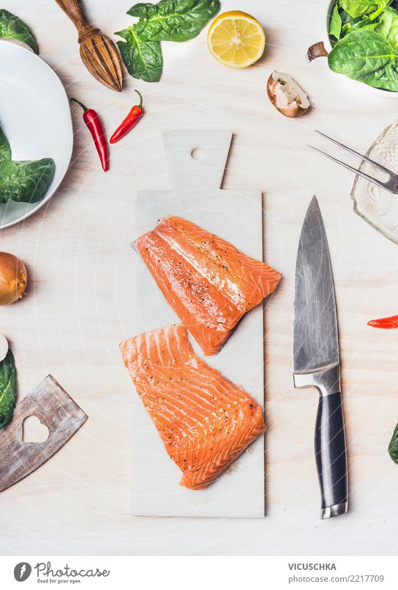 Lachsfilet auf wießem Schneidebrett mit Messer Lebensmittel Fisch Gemüse Salat Salatbeilage Kräuter & Gewürze Ernährung Mittagessen Abendessen Bioprodukte Diät