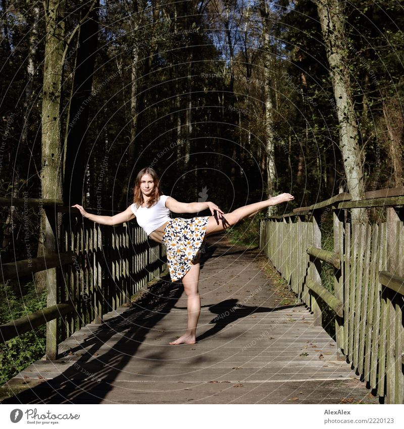 Junge, sehr sportliche Frau steht barfuß auf einer Holzbrücke im Wald und macht barfuß und bauchfrei eine Tanzpose Freude schön Fitness Leben Turnen Junge Frau