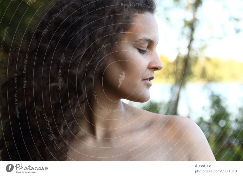 Seitliches Portrait einer großen, schönen Frau mit langen, dunklen, lockigen Haaren in der Natur elegant Haare & Frisuren Haut harmonisch Sinnesorgane Ausflug