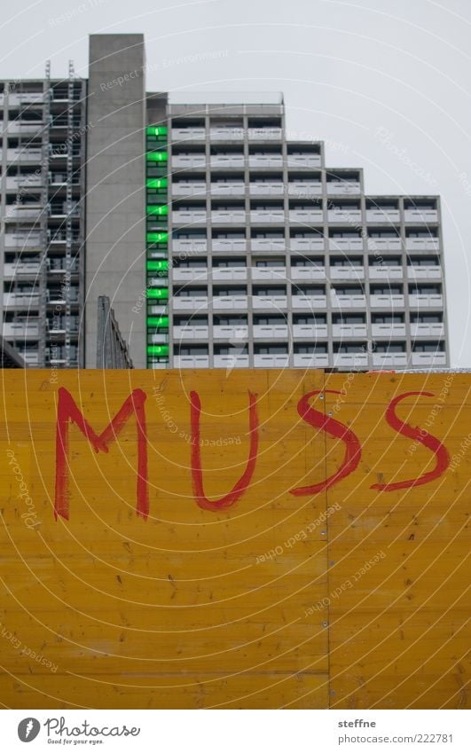 Irgendjemand muss doch München Haus Hochhaus Mauer Wand Fassade trist müssen Farbfoto Außenaufnahme Stadt Holzwand Bauzaun Text Großbuchstabe Typographie