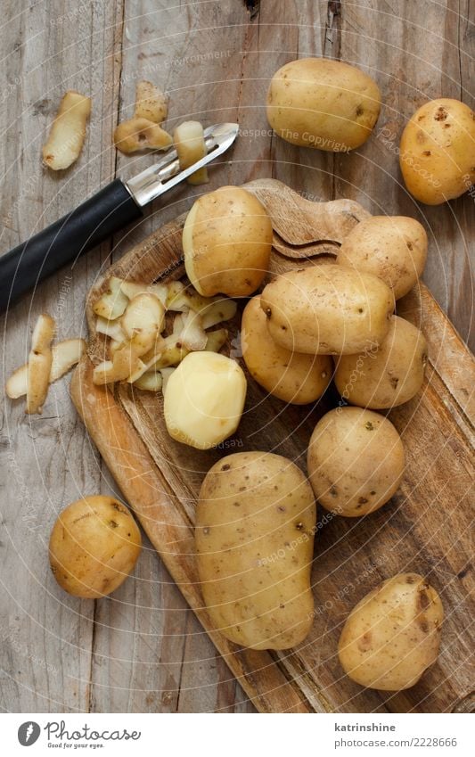 Rohe Kartoffeln mit einer Draufsicht des Gemüseschälers Lebensmittel Ernährung Vegetarische Ernährung Haut Menschengruppe Holz frisch braun Ackerbau