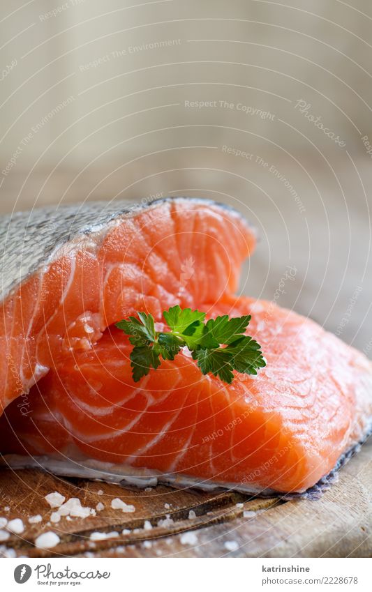 Frische rohe Lachse auf einem hölzernen Schneidebrett Meeresfrüchte Kräuter & Gewürze Ernährung Essen Abendessen Diät Tisch frisch grün rot Hintergrund