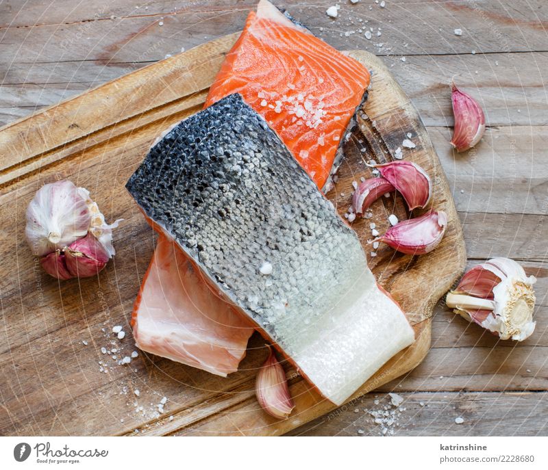 Frische rohe Lachse auf einem hölzernen Schneidebrett Meeresfrüchte Gemüse Ernährung Essen Abendessen Diät Tisch frisch oben rot Hintergrund Holzplatte