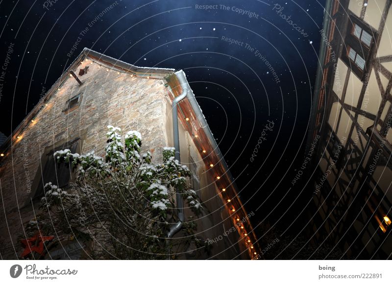 Maria und Josef suchen eine Herberge Haus Schneefall Stall Fachwerkfassade Fachwerkhaus Lichterkette Sternenhimmel Außenaufnahme Textfreiraum oben Nacht