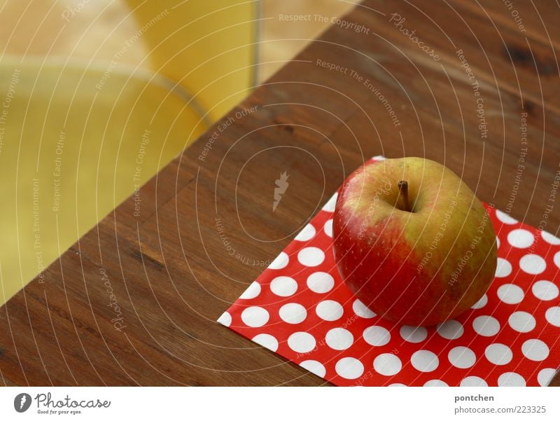 Ein Boskop Apfel liegt auf einem Tisch vor dem ein gelber Vintage Stuhl steht. Gesunde Ernährung, Obst Lebensmittel Gesundheit Dekoration & Verzierung Kitsch