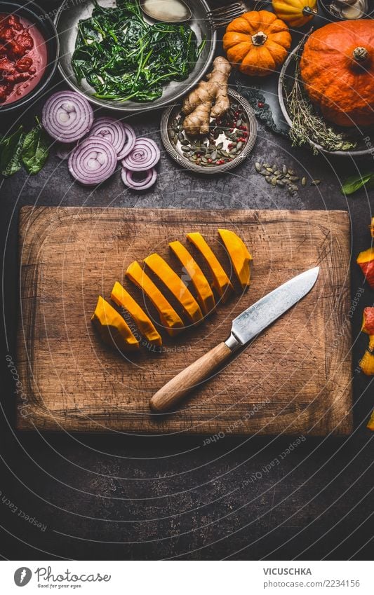 Geschnittene Kürbis auf dem Küchentisch mit Kochzutaten Lebensmittel Gemüse Kräuter & Gewürze Öl Ernährung Mittagessen Abendessen Festessen Bioprodukte