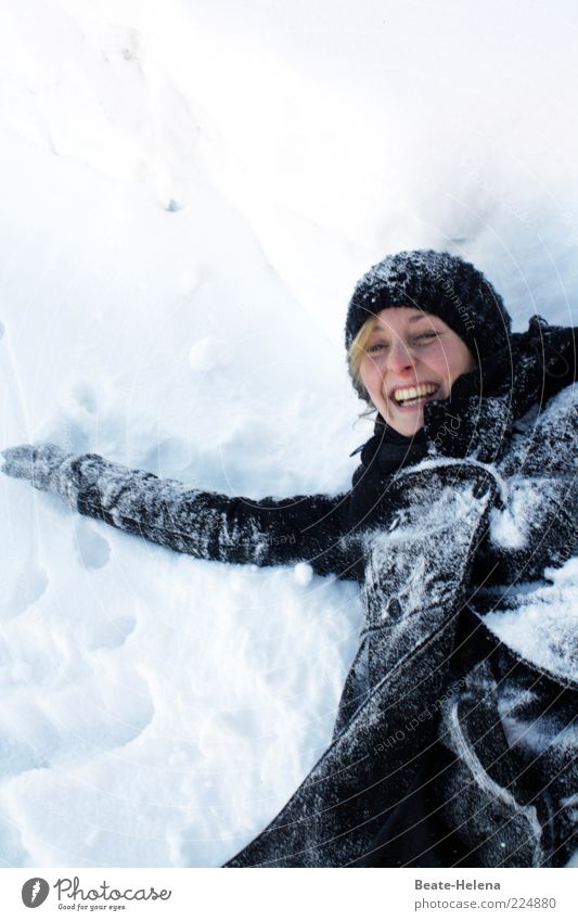 Schneefeste Stimmung! Junge Frau Jugendliche 1 Mensch 18-30 Jahre Erwachsene Natur Winter Mantel Mütze blond Erholung genießen lachen liegen leuchten toben