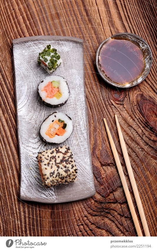 Sushi stellten auf Tonwarenplatte mit Essstäbchen und Sojasoße ein Lebensmittel Meeresfrüchte Mittagessen Teller Tisch Holz Rost frisch lecker oben Tradition