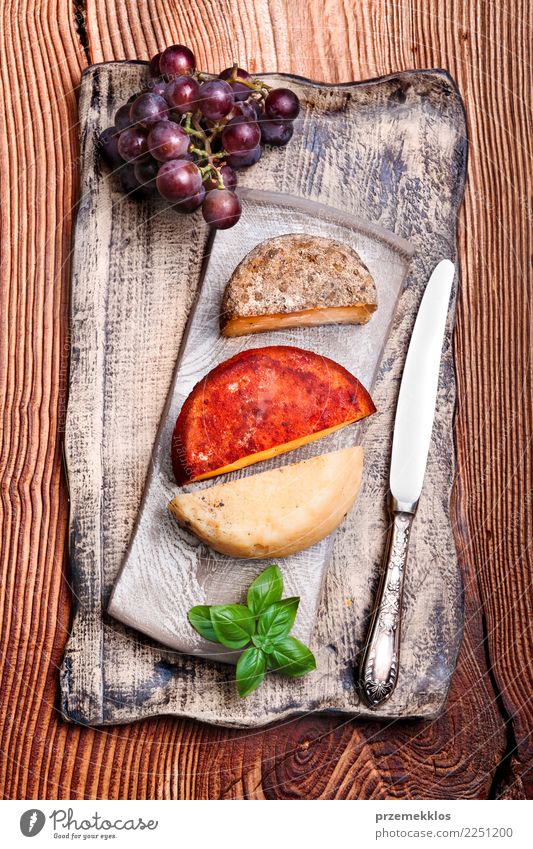 Käse und schwarze Trauben auf handgemachter Tonwarenplatte Lebensmittel Frucht Frühstück Mittagessen Teller Tisch Holz Rost frisch lecker oben Keramik