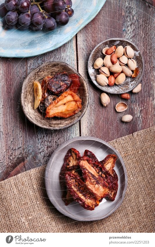 Trockenfrüchte und Nüsse in handgemachten Tonwarenschüsseln Lebensmittel Frucht Dessert Schalen & Schüsseln Tisch Holz Rost lecker oben Keramik getrocknet