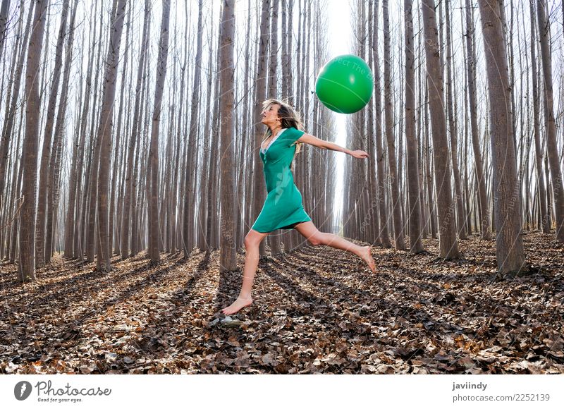 Blondes Mädchen, das in das Holz mit einem Ballon springt Lifestyle Freude schön Erholung Mensch Frau Erwachsene Natur Herbst Baum Blatt Park Wald blond