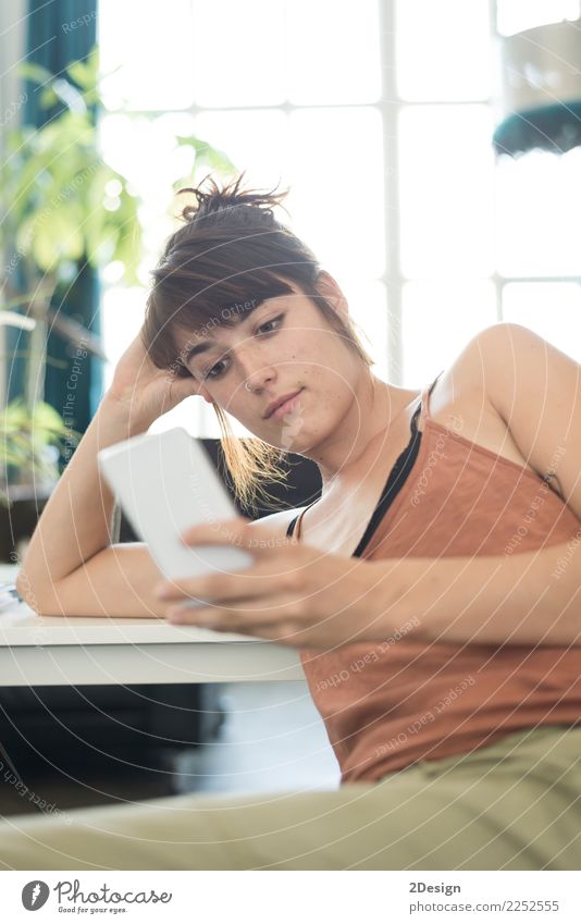 Glückliche junge Geschäftsfrau, die Handy im Büro verwendet Lifestyle lesen lernen Arbeit & Erwerbstätigkeit Beruf Arbeitsplatz Business Telefon PDA Computer