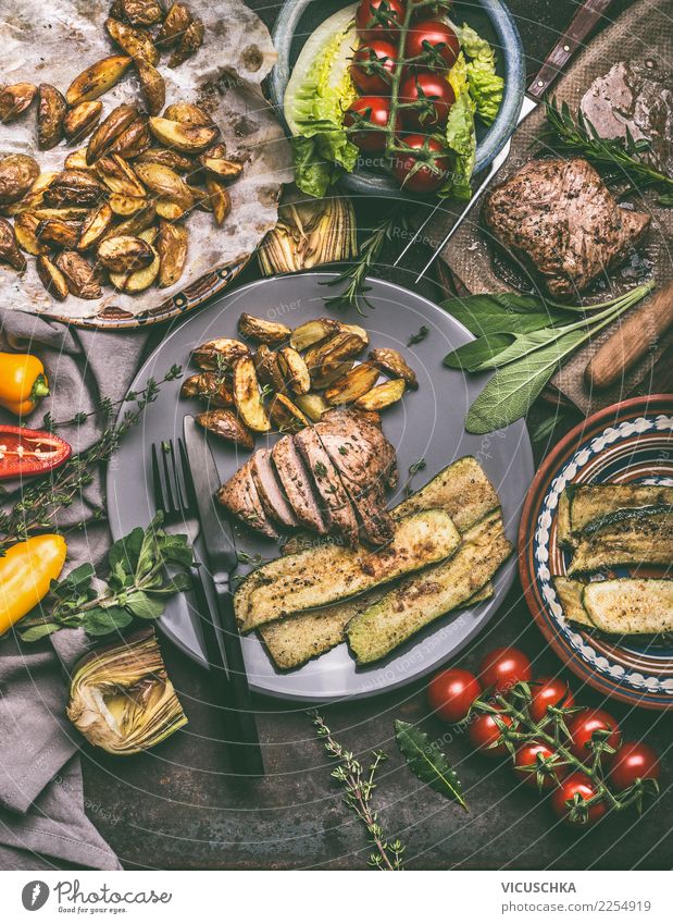 Essen mit gebratenem Fleisch, Bratkartoffeln und Gemüse Lebensmittel Salat Salatbeilage Ernährung Mittagessen Abendessen Bioprodukte Geschirr Teller Besteck