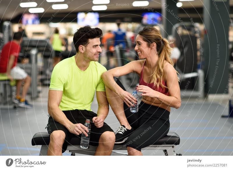 Personal Trainer des Mannes und der Frau in der Turnhalle. trinken Flasche Lifestyle Glück Körper Wellness Sport sprechen Mensch maskulin feminin Junge Frau