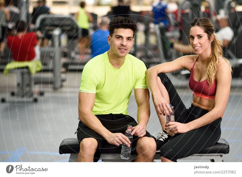 Personal Trainer des Mannes und der Frau in der Turnhalle. trinken Flasche Lifestyle Glück Körper Wellness Sport sprechen Mensch maskulin feminin Junge Frau