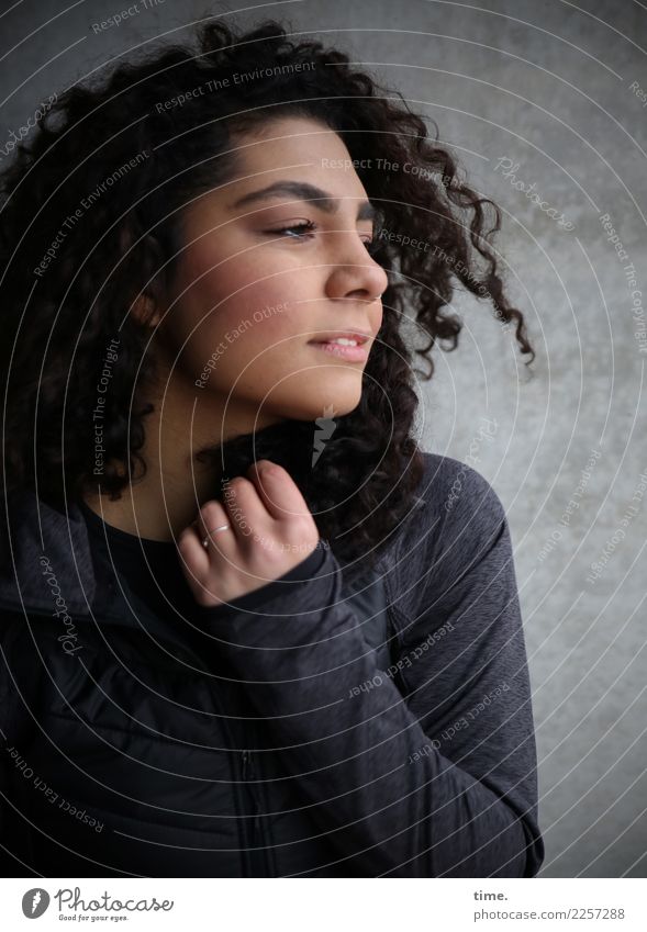 Nikolija feminin Frau Erwachsene 1 Mensch Mauer Wand Jacke Haare & Frisuren brünett langhaarig Locken beobachten festhalten Blick dunkel Freundlichkeit schön