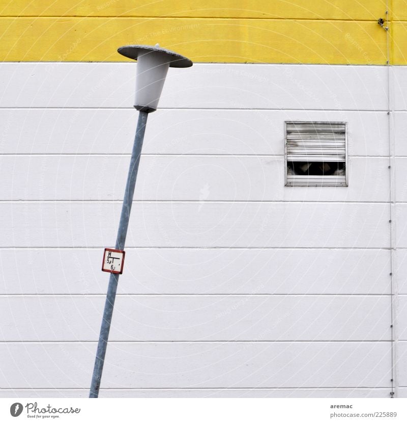 Schräglage Fabrik Bauwerk Architektur Mauer Wand Beton Zeichen gelb weiß Lampe Laterne Laternenpfahl Straßenbeleuchtung Farbfoto Außenaufnahme abstrakt