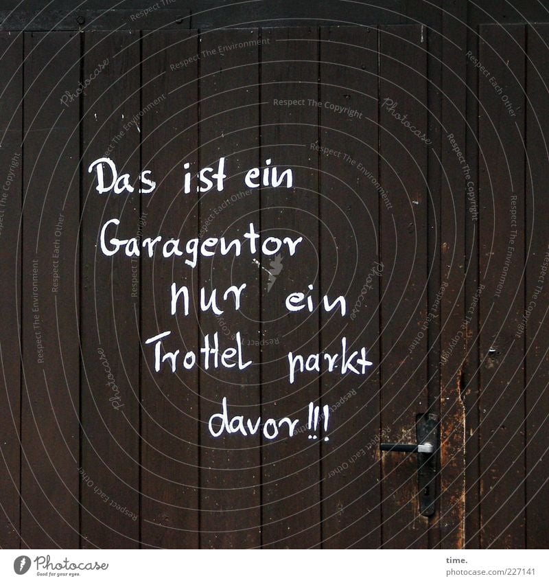 Dezenter Hinweis Hütte Tor Tür Holz braun Garage Garagentor Buchstaben Redewendung Reim Griff vertikal parallel Ansage Warnhinweis Warnung Parkplatz Dummkopf