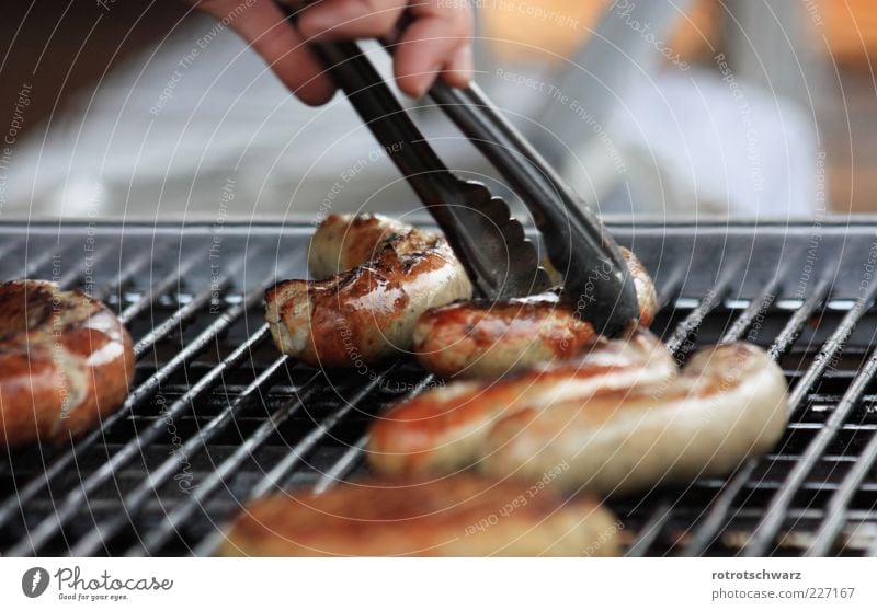 Bratwurst wird gegriffen Lebensmittel Wurstwaren Gastronomie Hand Grill braun Zange nehmen Gitter Kruste gebraten Grillsaison Thüringen Farbfoto mehrfarbig