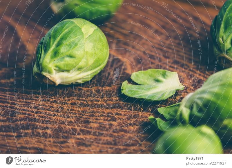 Rosenkohl Lebensmittel Gemüse Bioprodukte Vegetarische Ernährung Diät Schneidebrett Holz frisch braun gelb grün genießen roh Rohkost Farbfoto Nahaufnahme