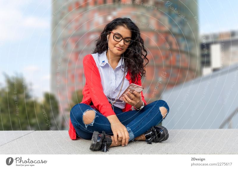 Eine hörende Musik der jungen Frau auf digitalem Tablettensitzen Freude Freiheit Sonne Entertainment Telefon MP3-Player Technik & Technologie Erwachsene