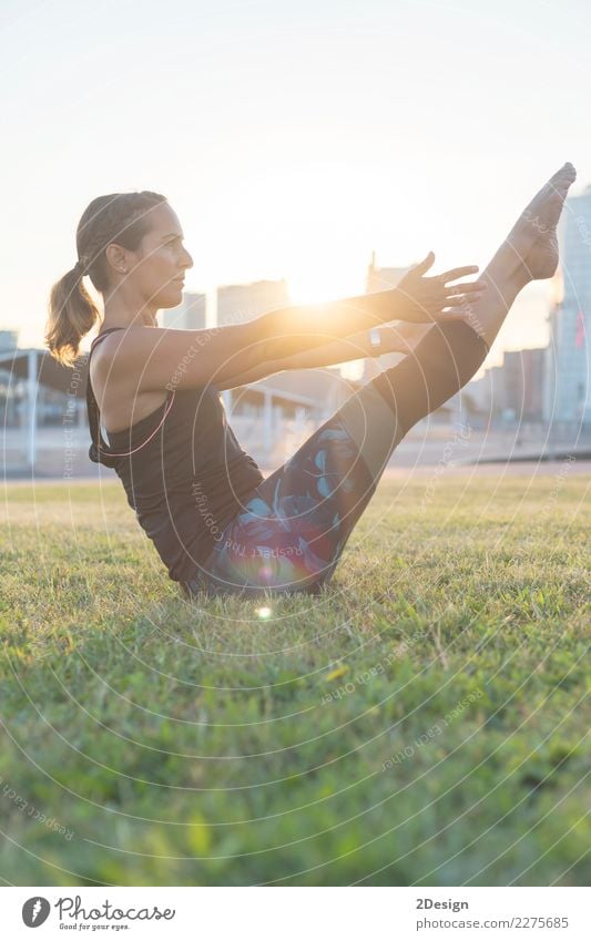 Schönes Mädchen nimmt an Yoga im Park teil Lifestyle harmonisch Erholung Sport Frau Erwachsene Jugendliche Natur Gras sitzen grün Kraft Konzentration