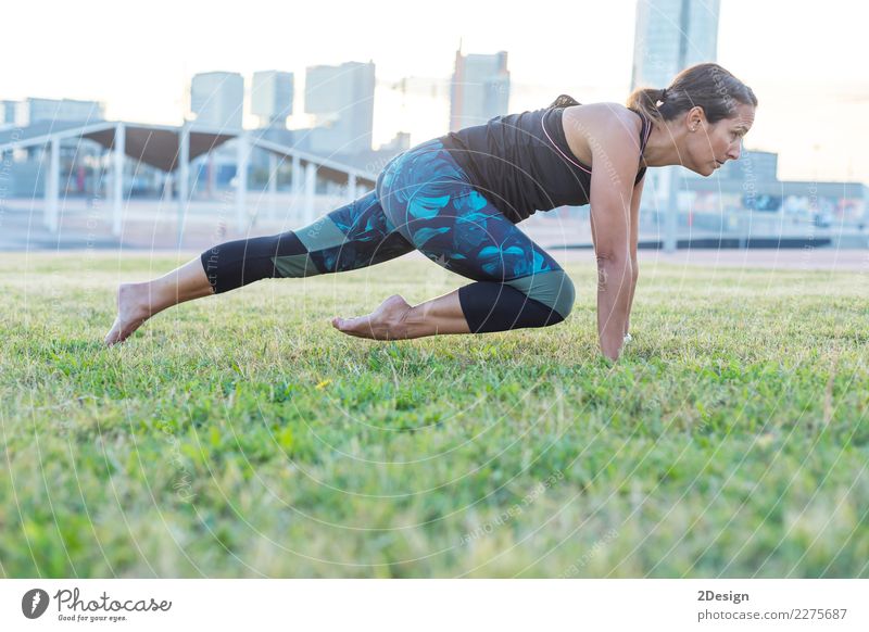 Schönes Mädchen nimmt an Yoga im Park teil Lifestyle harmonisch Erholung Sport Frau Erwachsene Jugendliche Natur Gras sitzen grün Kraft Konzentration