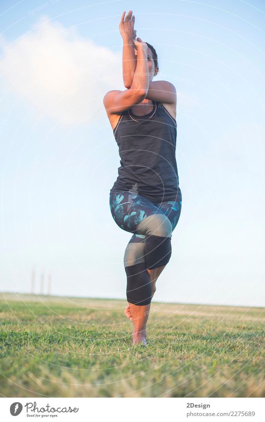 Schönes Mädchen nimmt an Yoga im Park teil Lifestyle harmonisch Erholung Sport Frau Erwachsene Jugendliche Natur Gras sitzen grün Kraft Konzentration