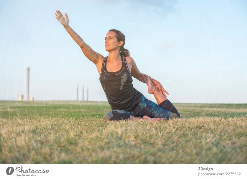 Schönes Mädchen nimmt an Yoga im Park teil Lifestyle harmonisch Erholung Sport Frau Erwachsene Jugendliche Natur Gras sitzen grün Kraft Konzentration